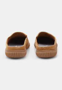 Smešane su sveže slip-on cipele od suede materijala u boji vanile, s teksturiranom površinom, zaobljenim zadnjim delom i fleksibilnim gumenim đonovima sa horizontalnim žljebovima.