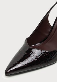 Chaussure slingback brillante bordeaux foncé à bout pointu avec texture en cuir de crocodile et doublure intérieure en cuir lisse.