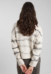 Maglione lavorato a maglia crema con righe grigie e accenti testurizzati, caratterizzato da un design accorciato e polsini a coste, mostrato sul retro.