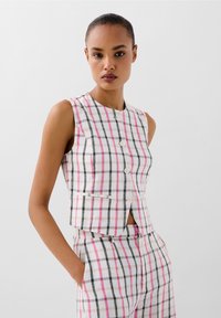 Gilet in lino misto con un motivo a quadri in bianco, rosa e nero. Presenta un collo rotondo, design senza maniche e chiusura frontale con bottoni.