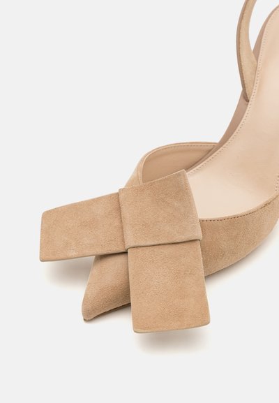 Beige ruskind slingback hæl med firkantet tå og en fremtrædende flad sløjfe foran, samt en glat inderside.