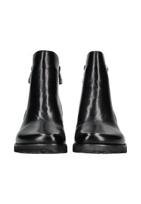 Bottes noires en cuir, à la cheville, avec une texture lisse, une forme fuselée et un petit talon. Présente des sangles latérales accentuées et des ferrures en métal.