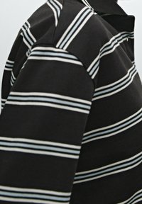 Black polo shirt featuring horizontal stripes in light blue and white, with a classic collar and short sleeves. Soft texture and fitted design.