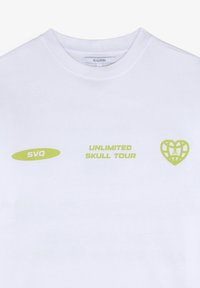 Witte katoen t-shirt met groene grafische tekst "UNLIMITED SKULL TOUR" en logo-accenten. Klassiek ontwerp met ronde hals, korte mouwen.