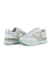 Weiße Netzsneaker mit grauen und silbernen Akzenten, ausgestattet mit einer strukturierten Oberfläche, gepolstertem Kragen und einer mintgrünen Sohle.