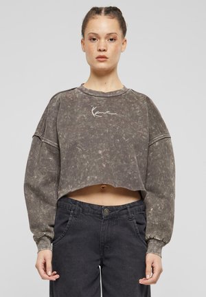 Felpa corta e oversize di colore grigio con texture marmorizzata, caratterizzata da maniche lunghe e un logo bianco in firma sul petto.