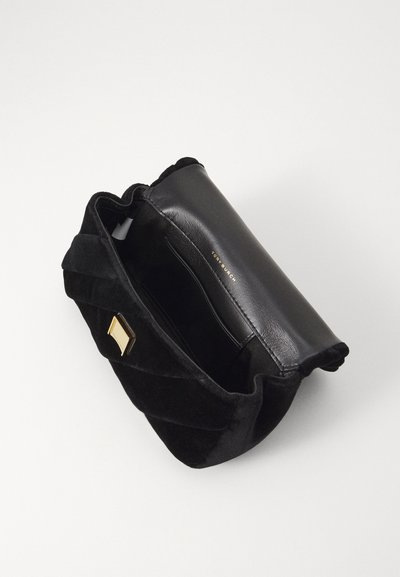 Borsa nera con un texture trapuntata in morbido materiale, con una patta in pelle liscia e un accentuazione in metallo dorato. Tasca interna visibile.