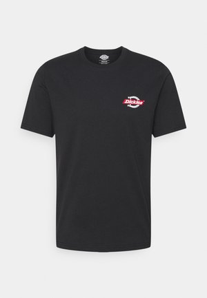 Black cotton t-shirt with short sleeves. Features a small red and white logo on the left chest. Classic crew neck design. Smooth texture.