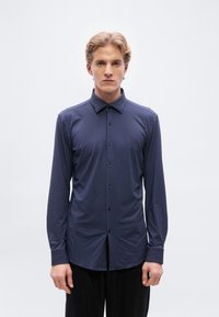 Μ ακρυμάνικο πουκάμισο σε ναυτικό μπλε με μικρό σχέδιο από λευκές πουά, με κουμπιά μπροστά και γιακά, κατασκευασμένο από λείο ύφασμα.