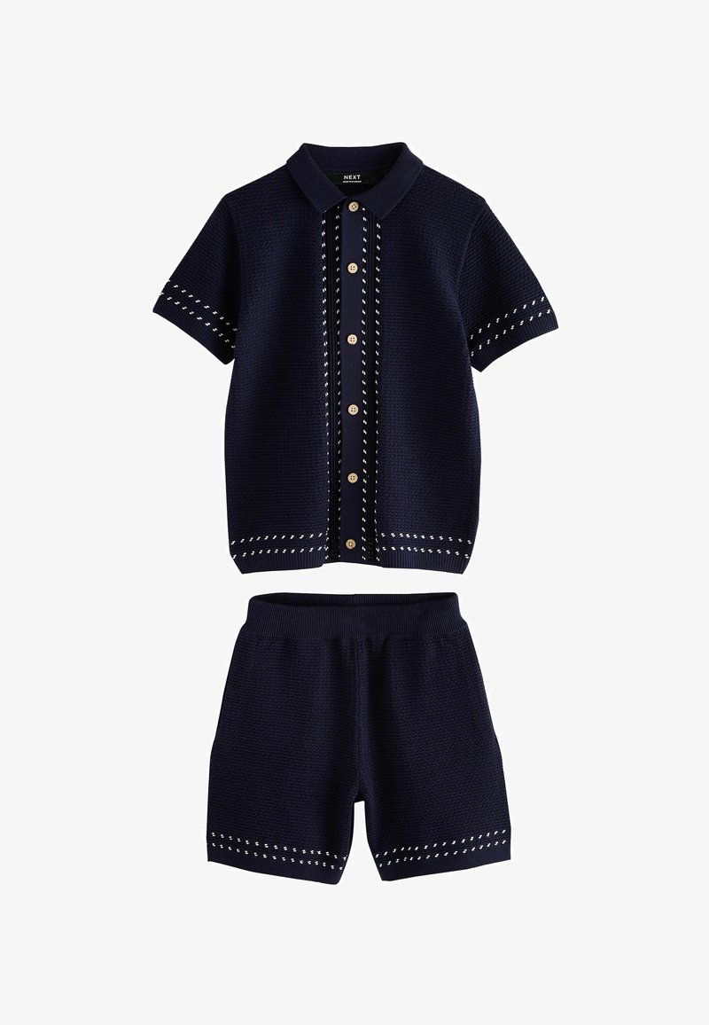 Marineblå strikket kortærmet skjorte med knapper og matchende strikkede shorts med hvide syningdetaljer.