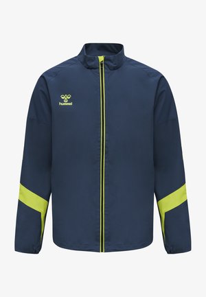 Marineblå sportsjakke med gule accenter og logo, der har en ståkrave, frontlynlås og lange ærmer med kontrasterende striber.