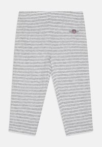 Lys grå leggings med hvite horisontale striper. Laget av mykt materiale, med en brodert logo på siden og en tettsittende design.