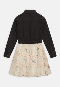 Czarne dżinsowe body z długimi rękawami i kołnierzykiem, zestawione z białą spódnicą o warstwowej budowie, zdobioną kwiatowym i ptasim wzorem, o miękkiej strukturze.