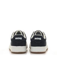 Schwarze Wildleder-Sneaker mit weißer Branding-Applikation an der Ferse, cremefarbenen Akzenten und einer dicken Gummisohle mit strukturierten Details.