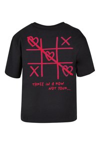 Zwarte t-shirt met een grafisch ontwerp van tic-tac-toe met rode lijnen, harten, en de tekst "DRIE OP EEN RIJ NIET JOUW..." op de achterkant.