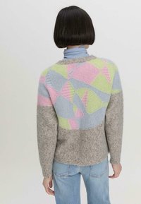Gebreide pullover in multicolore patronen van roze, groen en blauw, met een grijze body, geribde manchetten en een relaxte pasvorm. Textuur van het garen is zichtbaar.