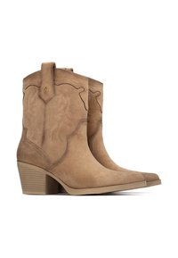 Botas de tobillo de ante marrón con puntas afiladas, costuras decorativas y pequeñas lengüetas. Cuentan con un tacón apilado y una textura suave.