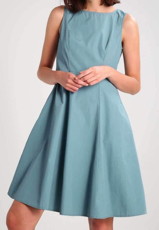 Une robe sans manches, de longueur genou, en tissu bleu doux avec un corsage ajusté et une jupe évasée, présentant un col rond classique.