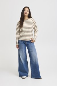 Striped beige and brown long-sleeve shirt paired with wide-leg blue jeans and gray shoes. Smooth fabric with a relaxed fit.
