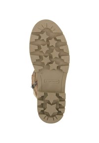 Chaussures marron avec une semelle en caoutchouc texturée comportant des motifs d'étoiles et un design robuste. Comprend une fermeture éclair sur le côté et un détail de logo de marque.