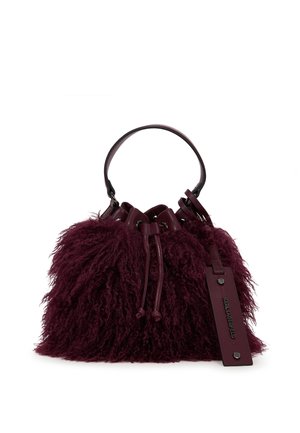 Burgunderfarbende Bucket-Bag aus wuscheligem, strukturiertem Fell mit einem glatten Ledertragegurt; verfügt über eine Kordelzugöffnung und einem Metallemblem für das Branding.