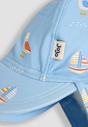 Casquette bleue arborant un motif ludique de goélands et de voiliers. Fabriquée en tissu lisse avec des coutures visibles et une étiquette sur le côté.