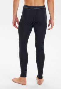 Black thermal leggings with a fitted design, smooth texture, and a branded waistband. Features snug cuffs at the ankles.