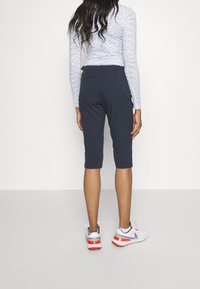 Marina korta träningsbyxor med en mjuk textur, med en åtsittande midja. Bärs med en mönstrad långärmad topp och sportskor.