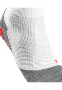 Chaussette de sport grise et blanche avec des accents rouges. Présente un design en tricot texturé et un orteil renforcé, conçu pour un ajustement sécurisé.
