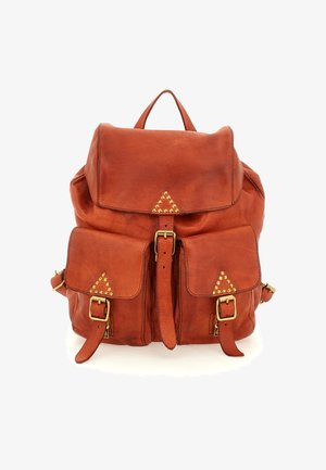 Zaino in pelle marrone con due tasche frontali, borchie dorate a forma di triangolo e chiusure con fibbie su sfondo bianco.