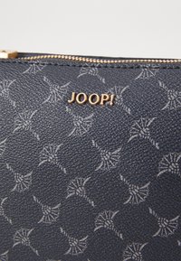 Navy textured synthetic leather wallet with a repeating embossed floral pattern and a gold "JOOP!" logo, featuring a smooth zipper closure.