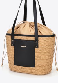 Woven straw tote bag with a black synthetic leather detail, drawstring closure, and two black carrying handles.