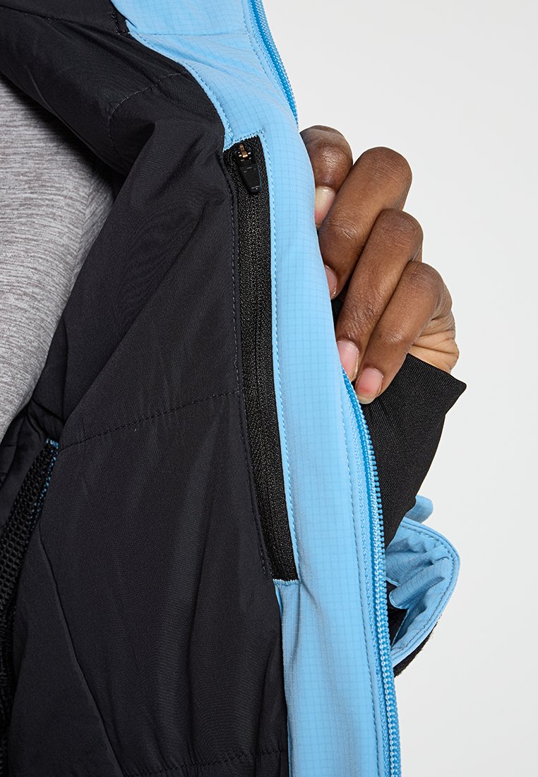Czarna wewnętrzna kurtka z jasnoniebieskim zamkiem. Posiada teksturowany niebieski materiał, kieszeń siatkową oraz gładką czarną podszewkę dla komfortu.