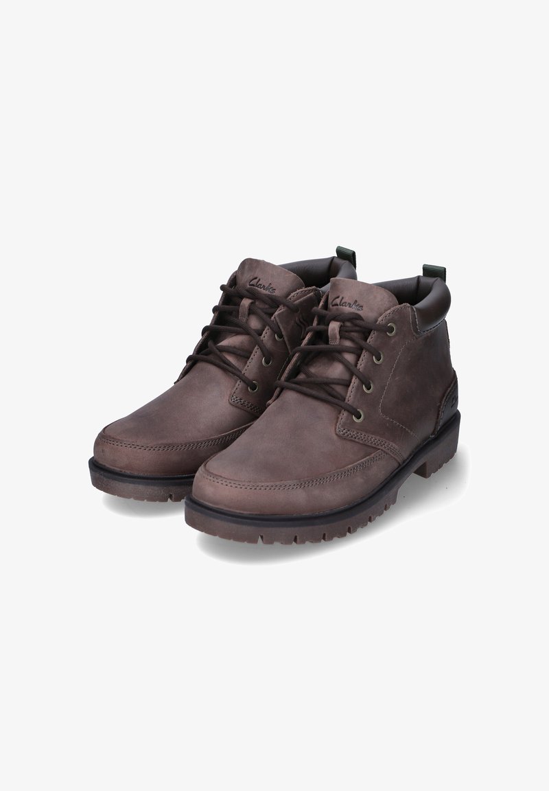 Bottes chelsea en cuir marron, avec un devant lacé, un bout arrondi et une semelle texturée. Dotées d'un col rembourré et d'une languette pour un enfilage facile.