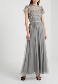 Graham Abendkleid mit einem Spitzentop, gepunkteter Textur, floraler Stickerei und einem fließenden Rock. Verfügt über kurze, Rüschendetails an den Ärmeln und eine taillierte Taille.