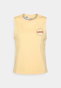 Gul ärmlös bomullströja med en cirkulär Levi's-logotyp i rosa och blått på vänster bröstområde. Smoother textur, klassisk rund hals.