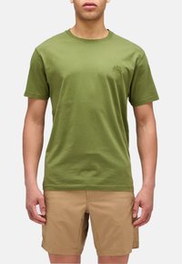 T-shirt in cotone verde oliva con collo rotondo, maniche corte e un piccolo logo stampato sul lato sinistro del petto. Design semplice; senza motivi o accenti.