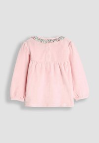 Rosa Langarm-Babyoberteil mit floralem Rüschensaum, gerafftem Saum und zwei Druckknöpfen auf der Rückseite, vor einem hellgrauen Hintergrund.