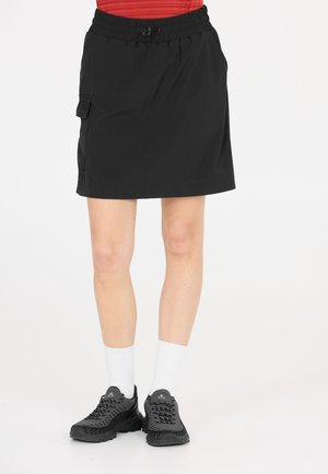 Svart knälång kjol med elastisk midja och dragsko. Har sidofickor av modell cargo och en mjuk tygkvalitet. Matchas med svarta sneakers.