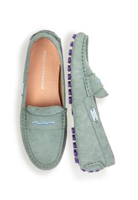 Mocassini verde con texture e dettagli in gomma viola, caratterizzati da un design slip-on e sottili motivi a onda. Fodera interna liscia.