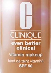 Clinique Even Better Clinical vitamin makeup-flaska, tan vätskegrund, vit text, SPF 50, stilren design med rundad topp.