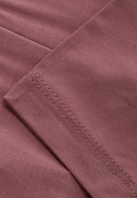Mauve stof met een geribbeld textuur, met een platte naad en contrasterend beige stiksel. Glad, flexibel en zacht aanvoelend.