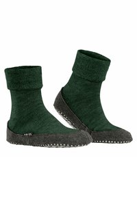 Calzini lavorati a maglia verde scuro con orlo pieghevole e suola grigia simile al feltro. Parte superiore testurizzata con grip in gomma a pois sul fondo per aumentare l'aderenza.