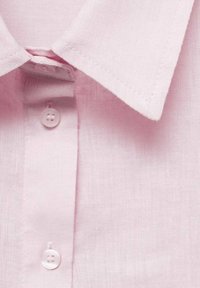 Helles rosa kurzärmliges Hemd mit spitzem Kragen, ausgestattet mit einer Leinenstruktur und zwei Knöpfen am Kragenöffnungs.