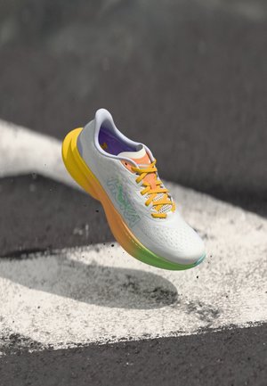 Chaussure de course Hoka avec une tige en mesh blanc, une semelle extérieure jaune, des accents orange et une semelle intermédiaire à dégradé coloré. Design léger avec des détails en mesh.