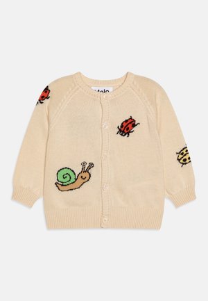 Cardigan beige boutonné avec des motifs tricotés d’un escargot vert, ainsi que des coccinelles rouges et jaunes sur le devant et les manches.