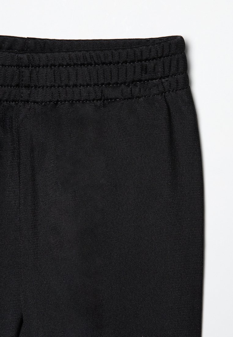 Un pantalon de sport noir avec une taille élastique, un tissu lisse et une coupe fuselée. Pas de motifs visibles ni d'accents supplémentaires.