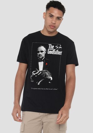 Black cotton t-shirt featuring a graphic print of a man in a tuxedo holding a cat, with "The Godfather" text and quote in white.
