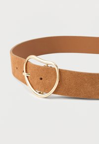 Ceinture en daim couleur tan avec une boucle ronde en or et une finition lisse, dotée de trous pour ajustement tout au long de sa longueur.