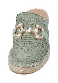 Grön vävd espadrille med rundad form, prydd med ett guld- och kristallaccent. Har en sula av jute och ett strukturerat ovandel.